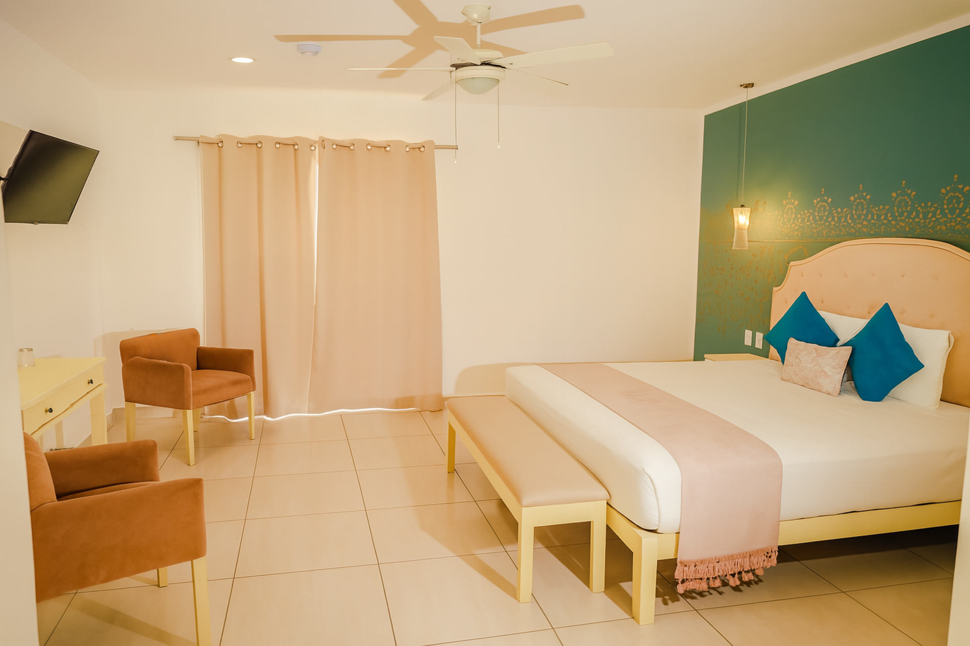 Bedroom with bed, chairs, and bench; teal and pink accents; neutral walls.