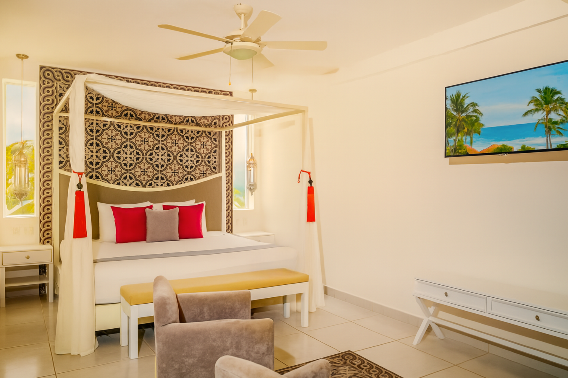 Bedroom with a four-poster bed, accent pillows, a bench, and a wall-mounted TV.
