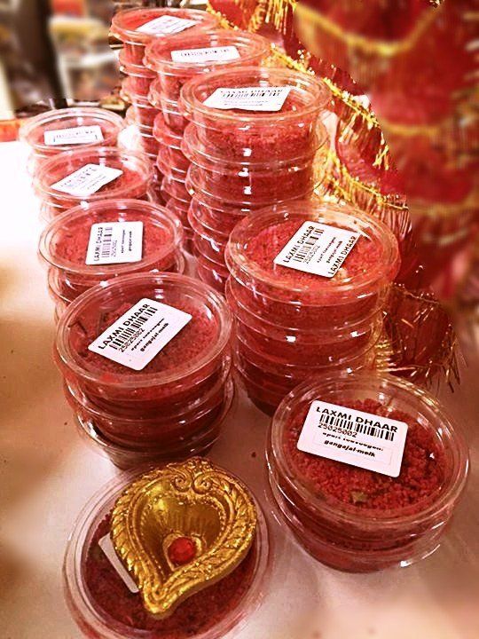 Een stapel plastic bakjes gevuld met rood poeder op een tafel.