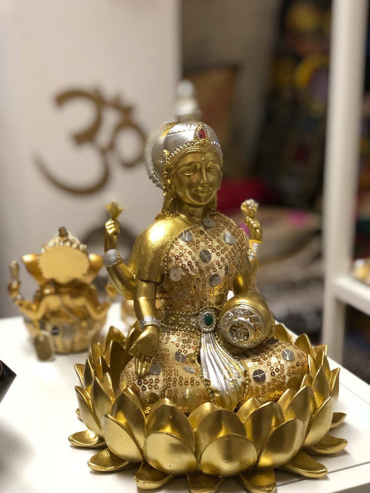 Een gouden beeld van een vrouw zittend op een lotusbloem.