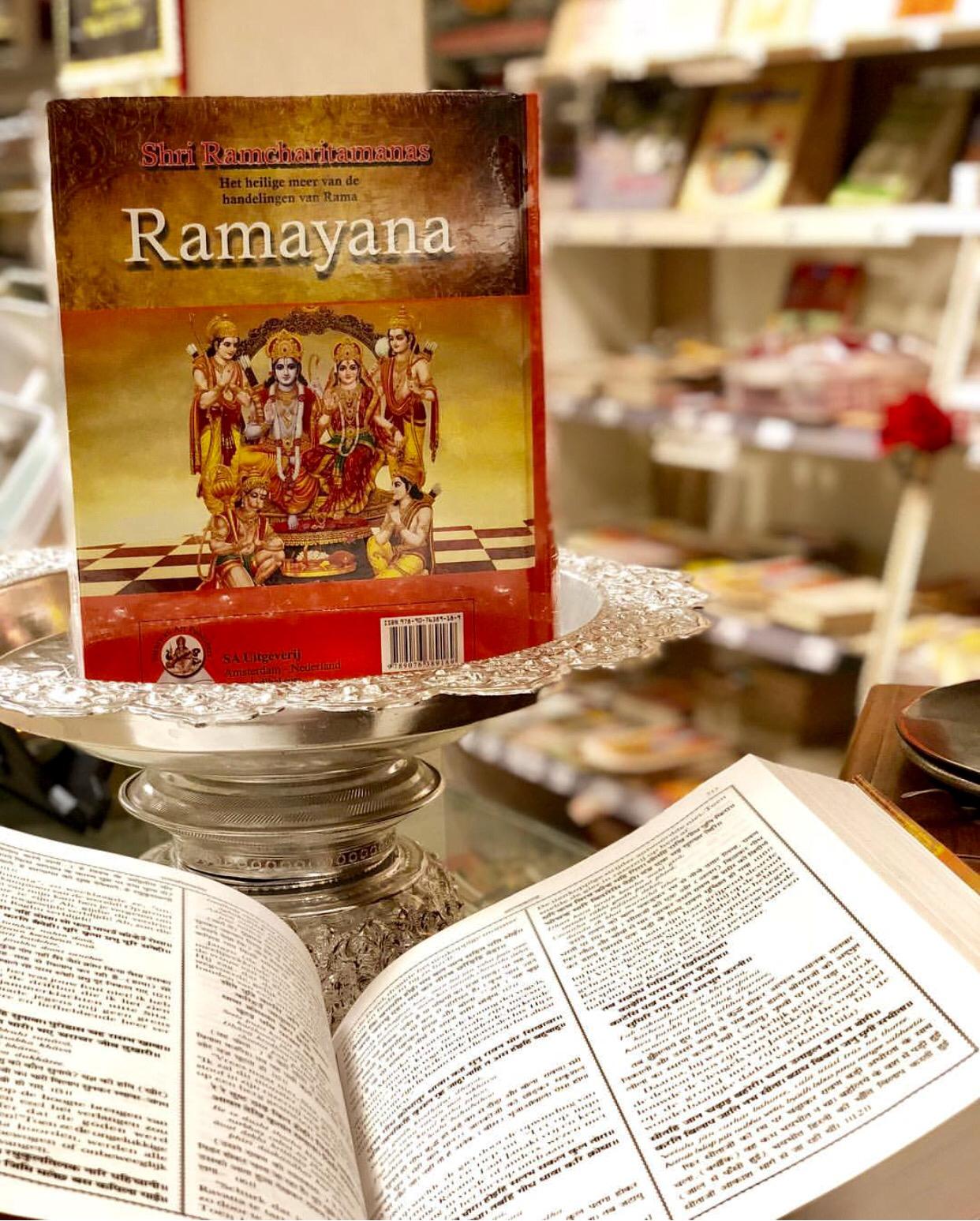 Een boek met de titel ramayana zit bovenop een open boek.