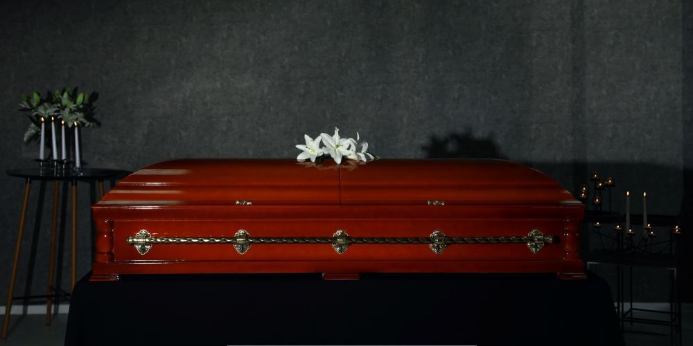 Traditional wooden casket with lilies displayed during a memorial service by a funeral home and cremations in Hudson Oaks, TX
