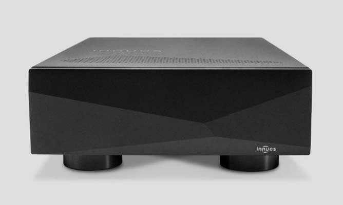 A black audiophile network switch is sitting on a white surface