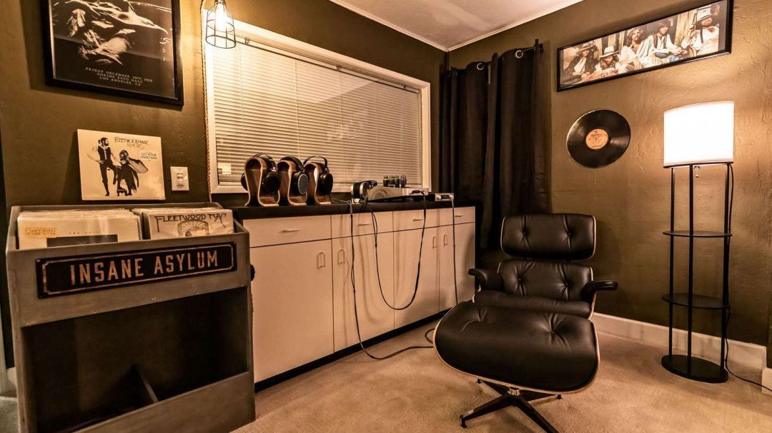 A room with a chair, ottoman, and record player