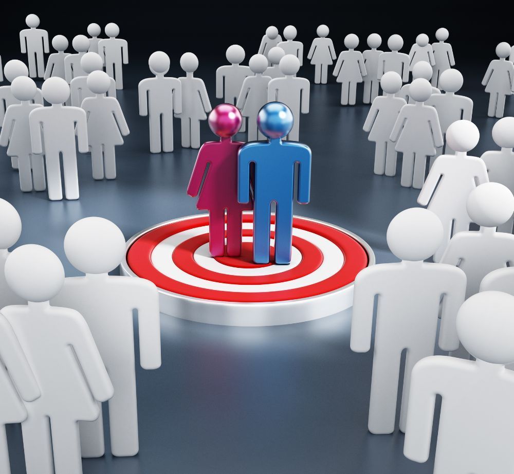 Un hombre y una mujer están parados en un objetivo en medio de una multitud de personas.