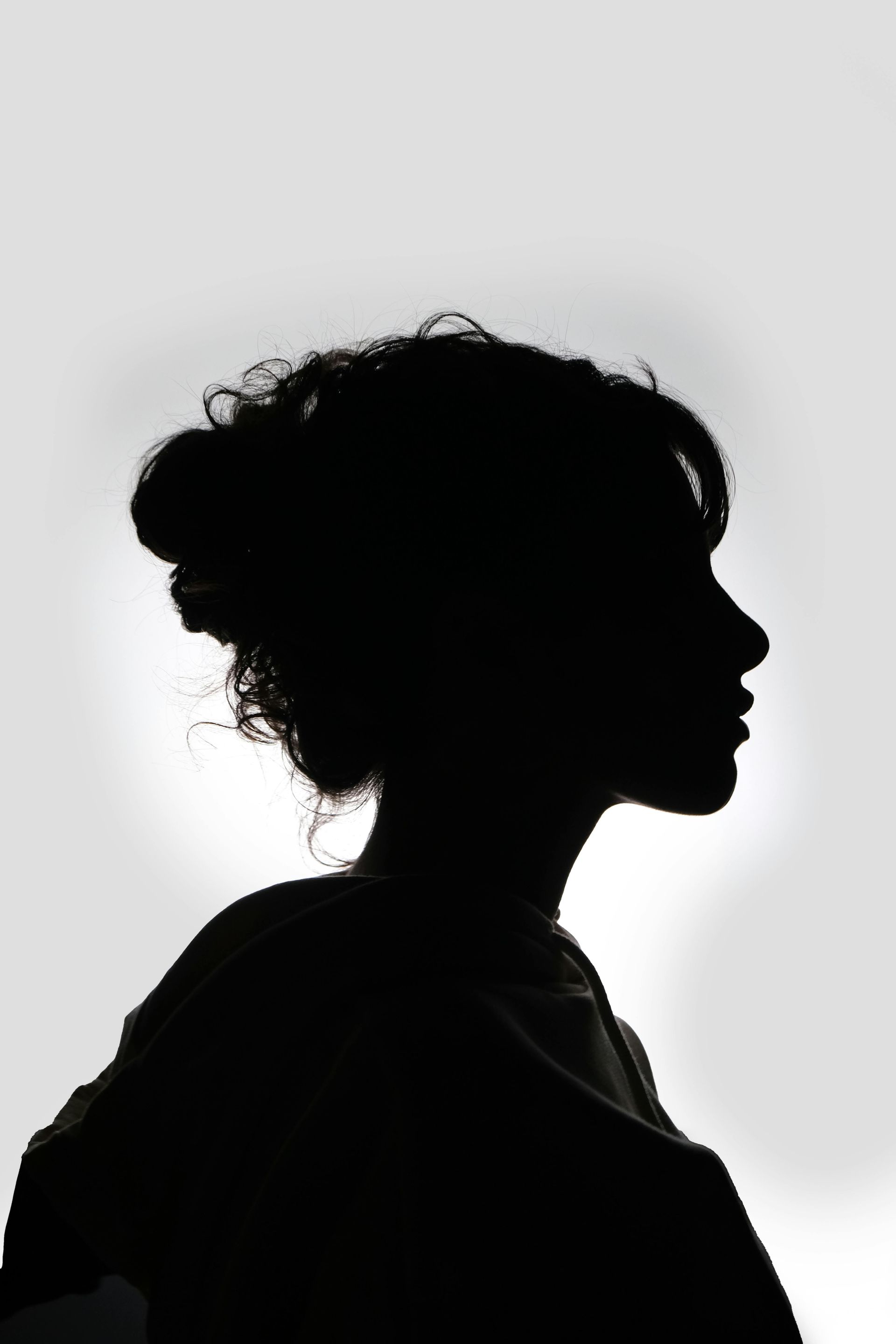 Una silueta de una mujer con cabello rizado recogido en un moño.