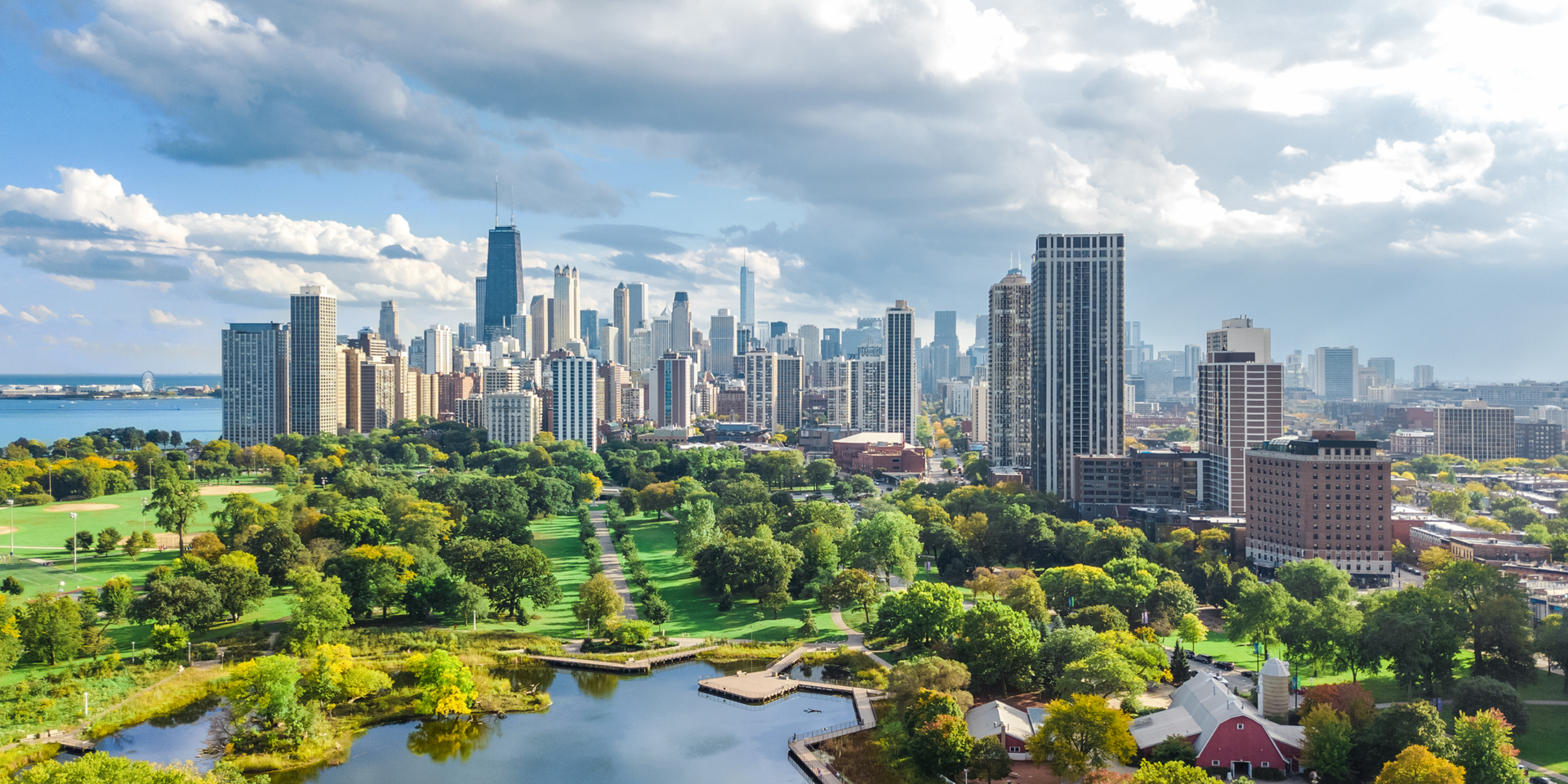 Chicago skyline with park in the foreground under a cloudy sky.