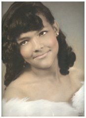 A woman in a white dress is smiling for the camera.