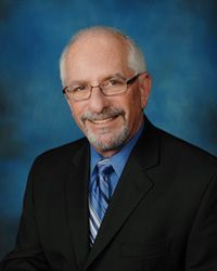 A man in a suit and tie is smiling for the camera.