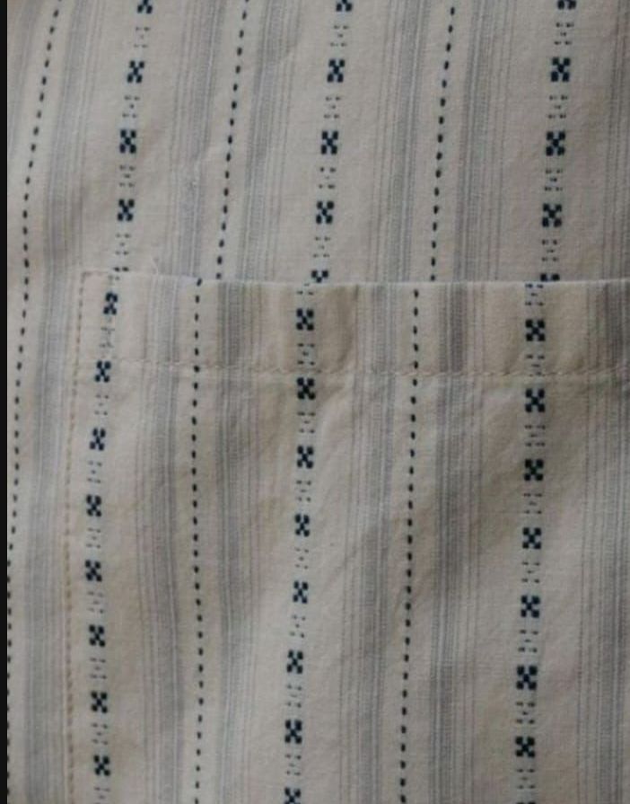 A close up of a white cloth with black stitching