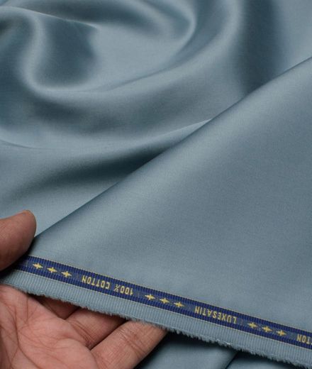 A person is holding a piece of blue satin fabric
