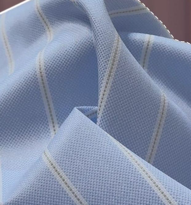 A close up of a piece of light blue fabric with white stripes