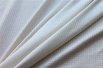 A close up of a piece of white fabric with polka dots on it.