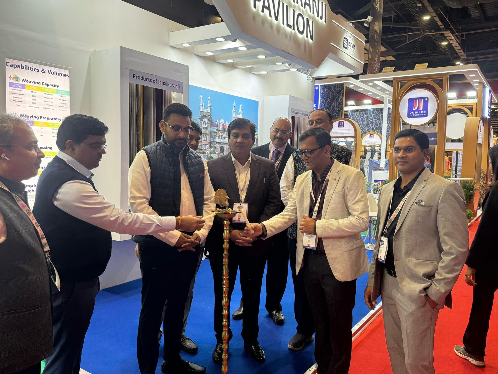 A group of men are standing around a pole at a convention.