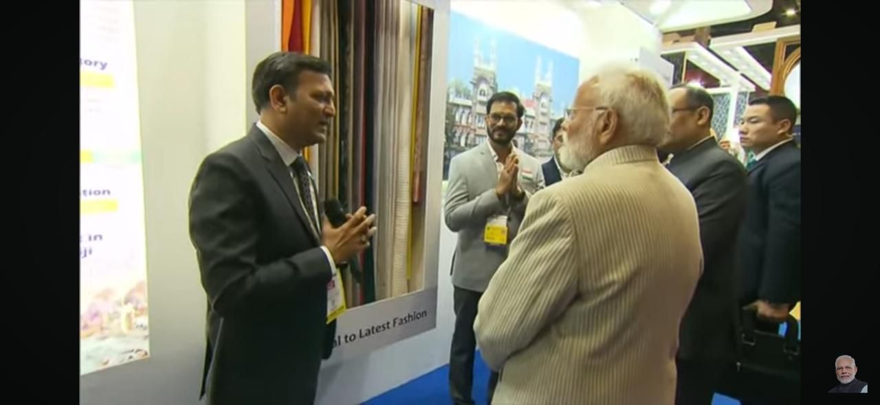 A group of men are standing in front of a wall talking to each other.