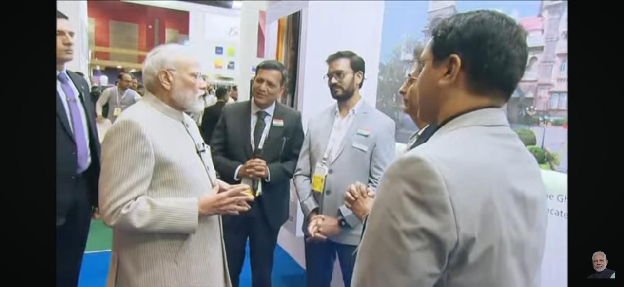 A group of men are standing around a man in a suit talking to him.