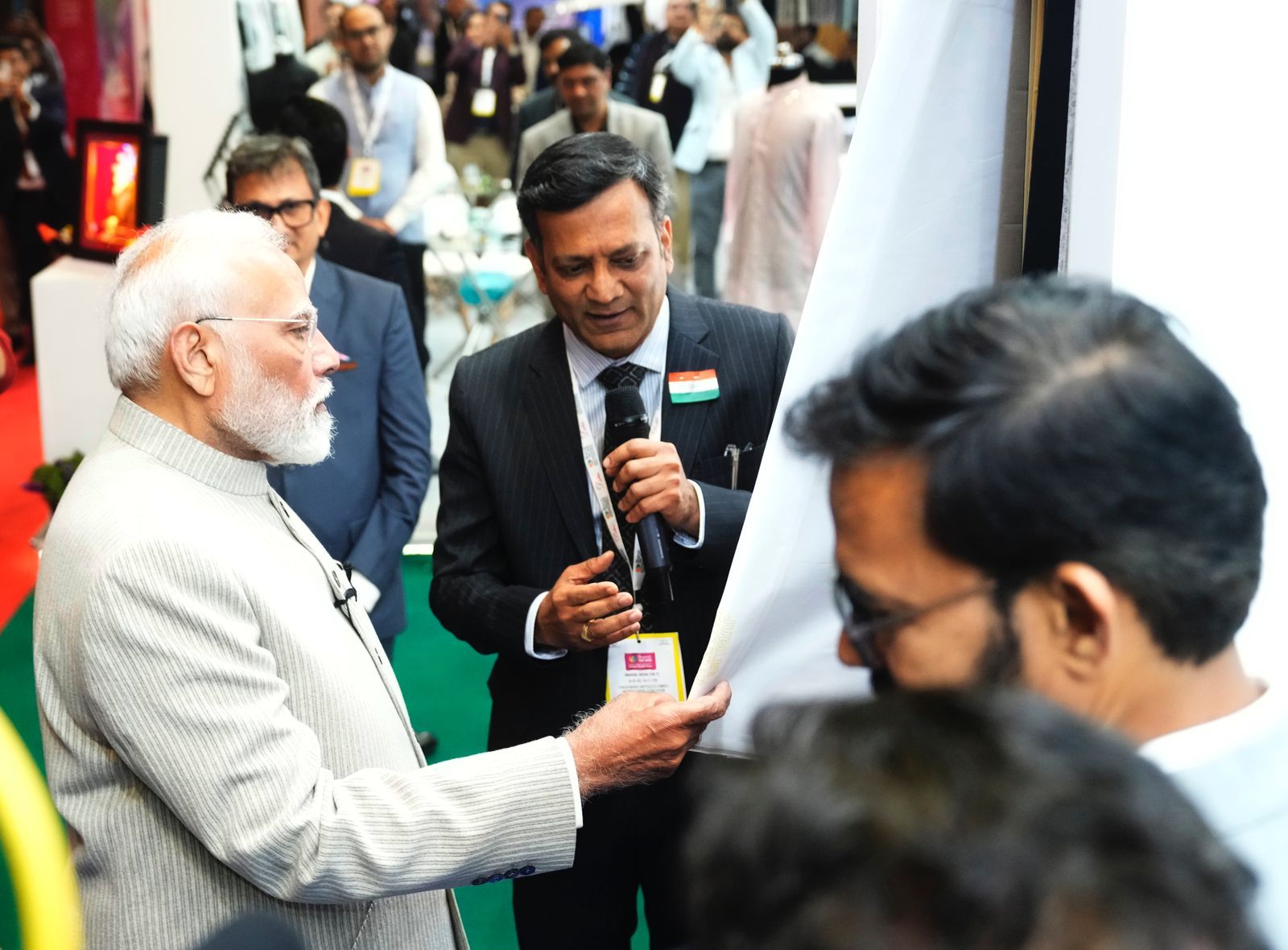 A group of men are standing around a man holding a microphone.