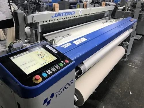 A blue and white toyota loom is sitting in a factory.