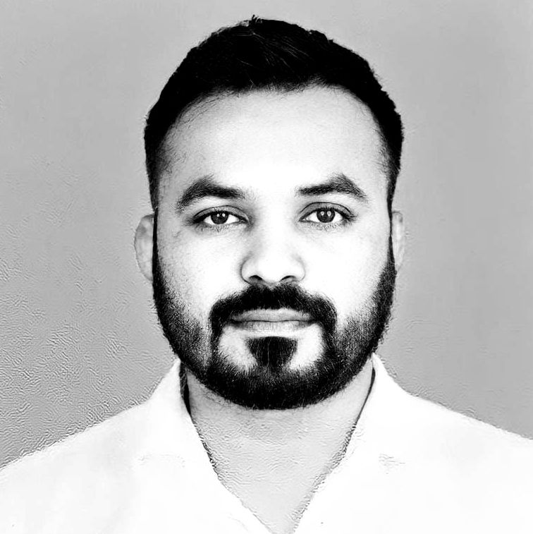 A black and white photo of a man with a beard wearing a white shirt.