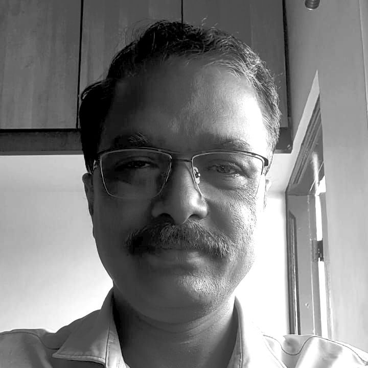 A black and white photo of a man with glasses and a mustache.