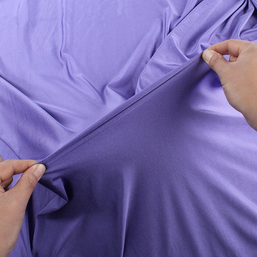 A person is stretching a piece of purple fabric.