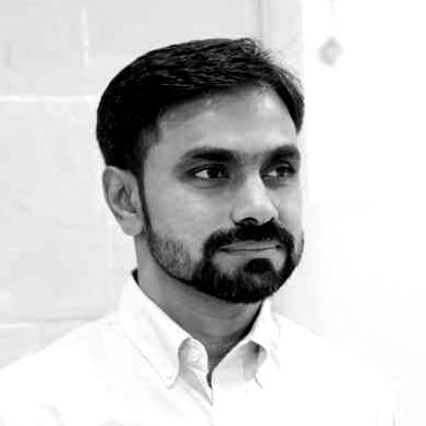 A black and white photo of a man with a beard wearing a white shirt.