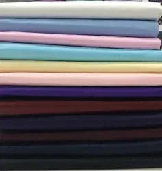 A stack of different colored fabrics is sitting on top of each other on a table.