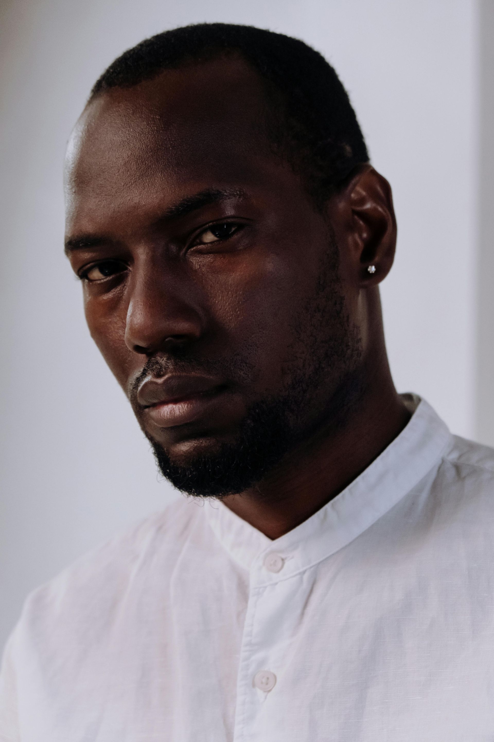 A man with a beard is wearing a white shirt