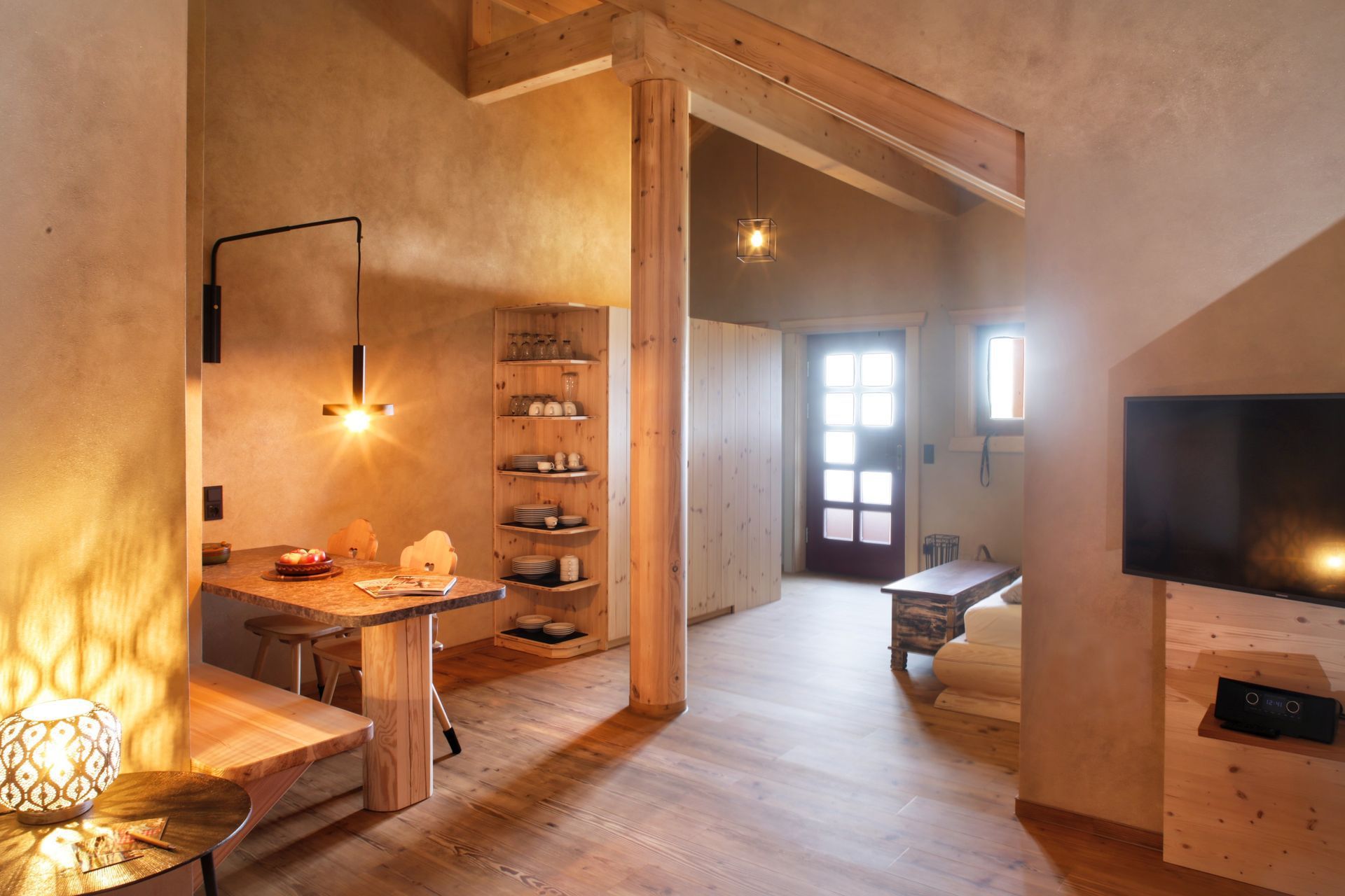 Ein Wohnzimmer mit einem Tisch und einem Flachbildfernseher