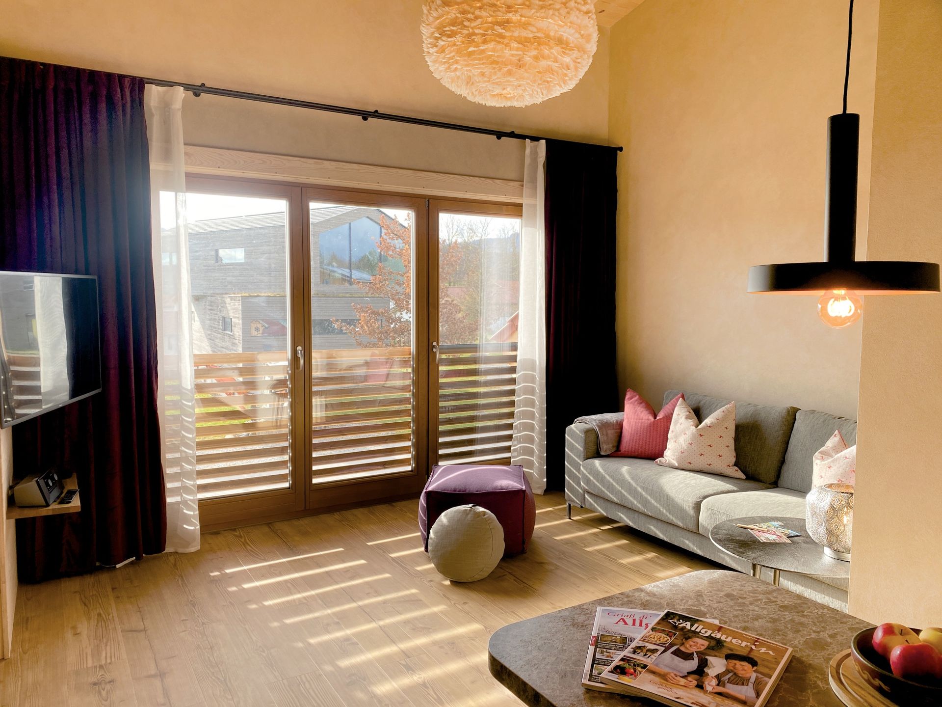 Ein Wohnzimmer mit Sofa, Tisch und Glasschiebetüren.