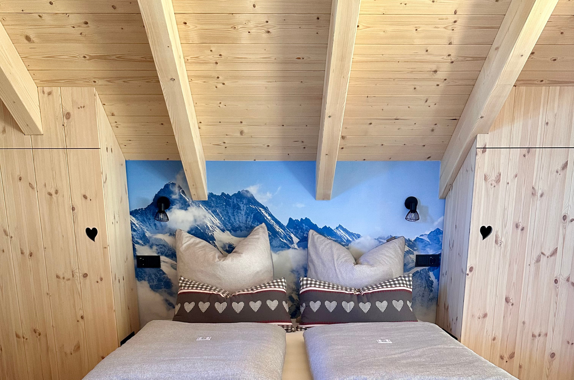 Bett mit Fototapete Zugspitze Fichte Schränke mit Herz Bettdecken und Kissen Chalet-Stil Holz