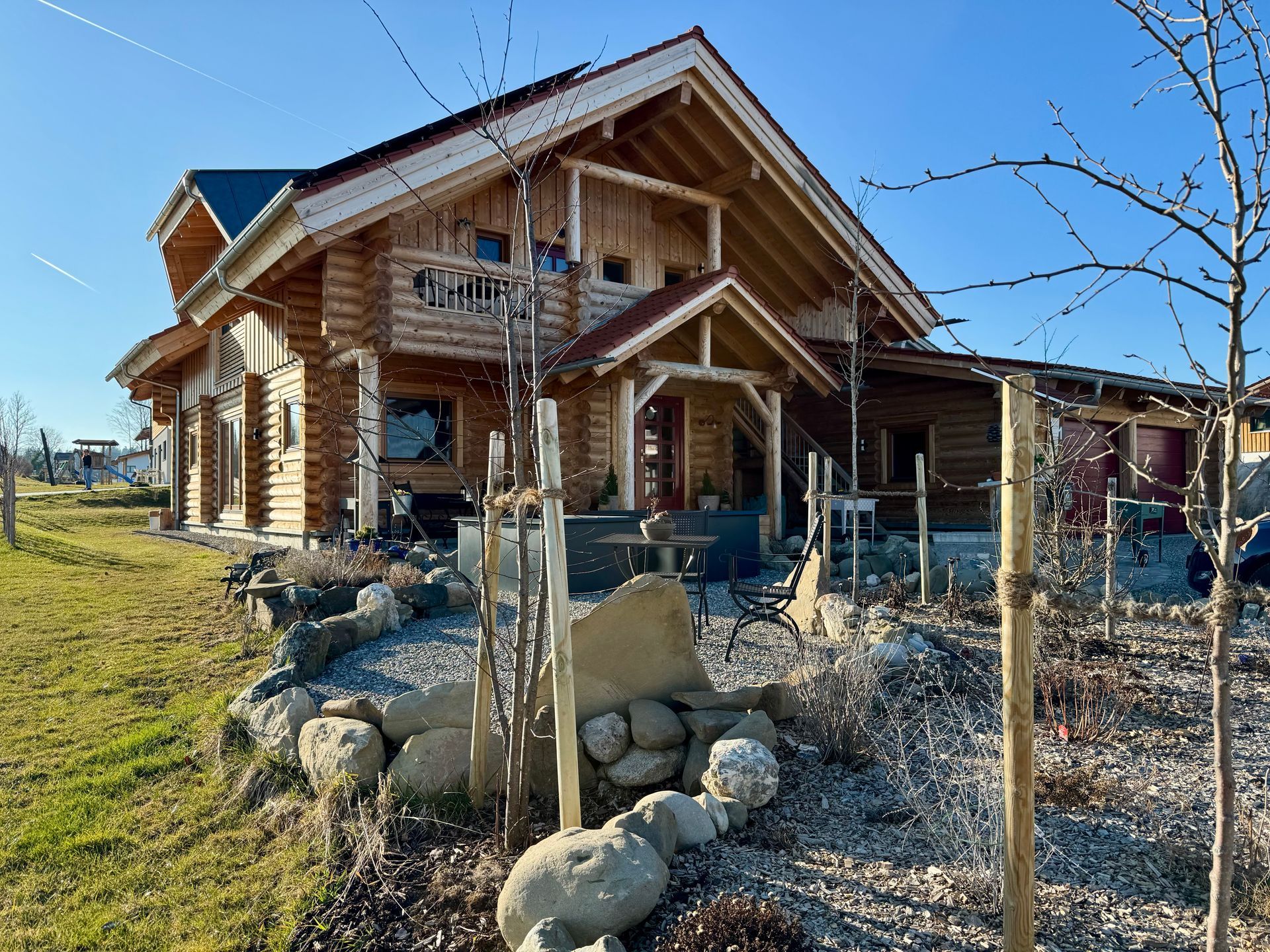 Ein großes Holzhaus ist von Felsen und Gras umgeben.