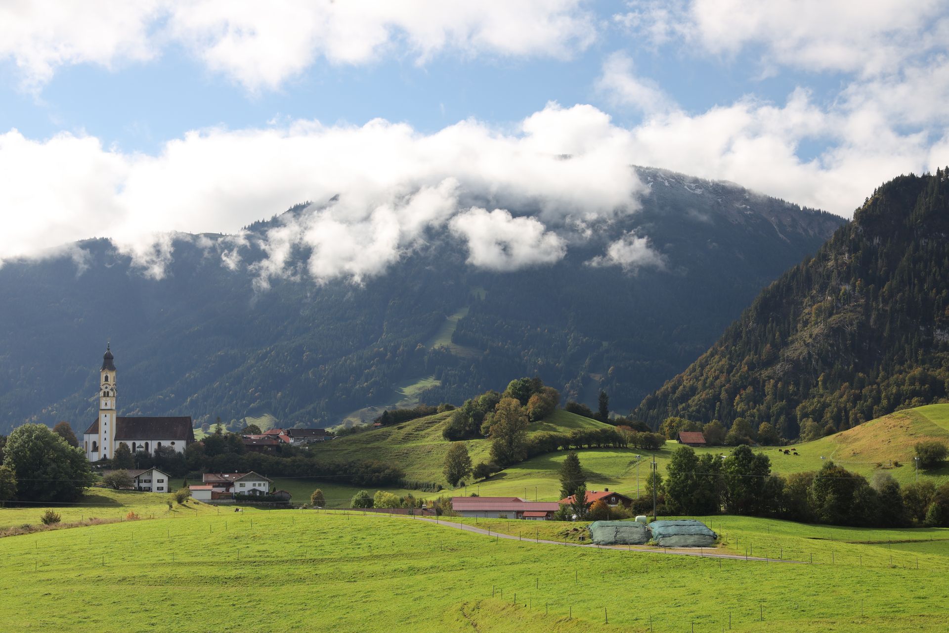 Eine Kirche mitten auf einem Feld mit Bergen im Hintergrund