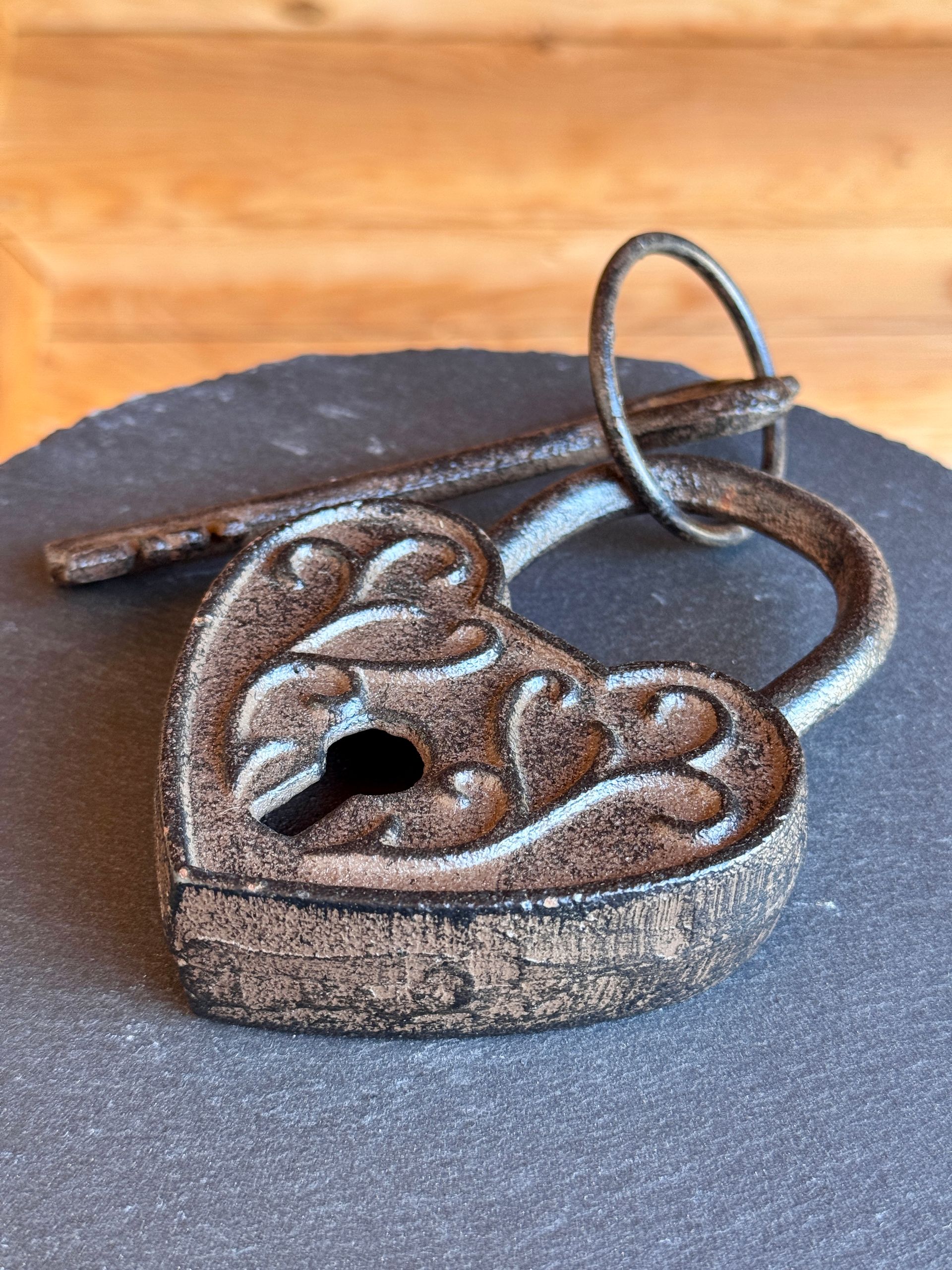 Auf einem Tisch liegt ein herzförmiges Vorhängeschloss mit Schlüssel.