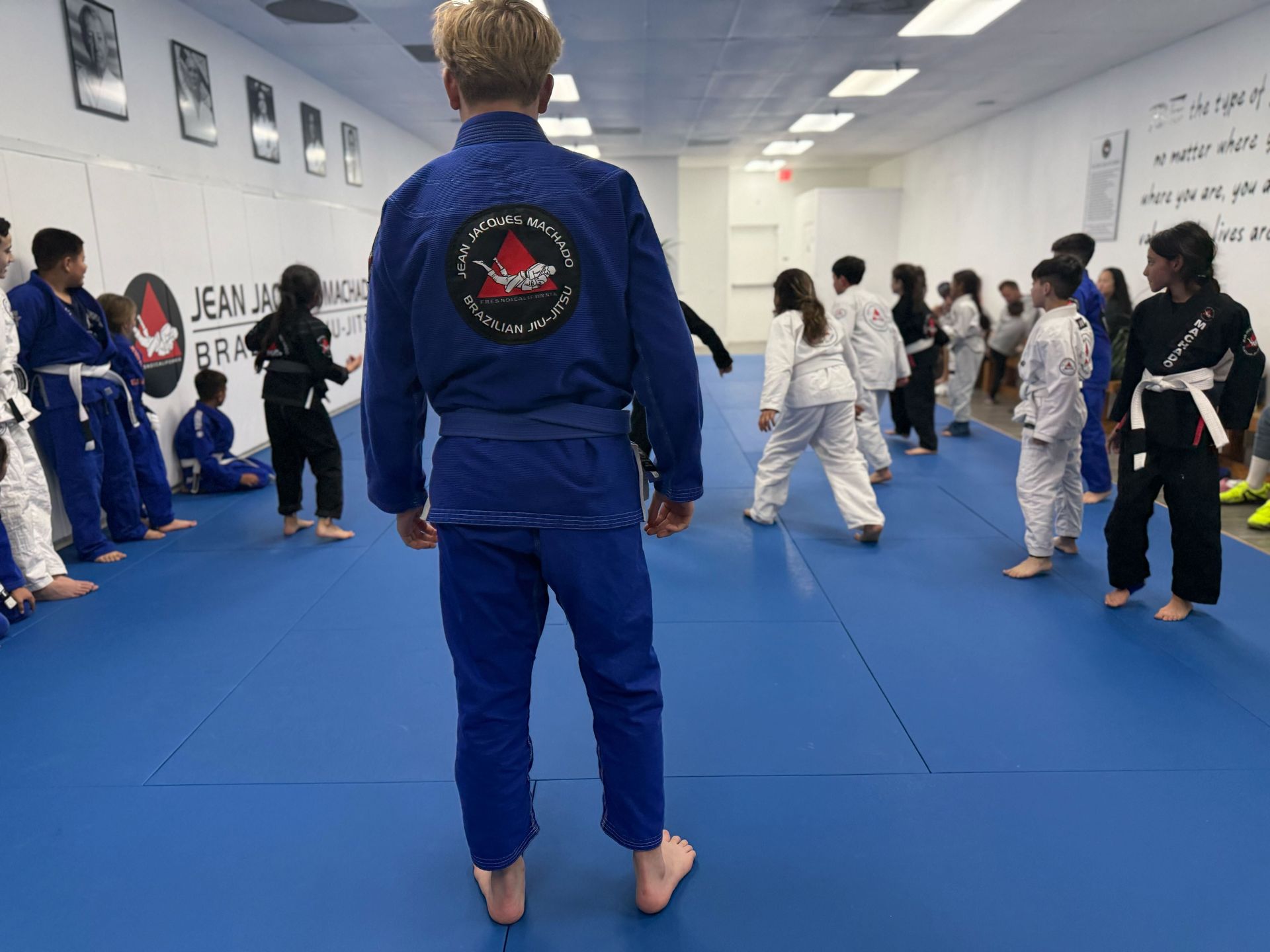 Teenagers practicing Brazilian Jiu-Jitsu techniques during martial arts class.