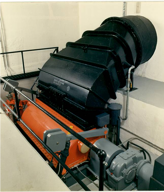 Black and orange machinery in a white room, possibly a turbine.
