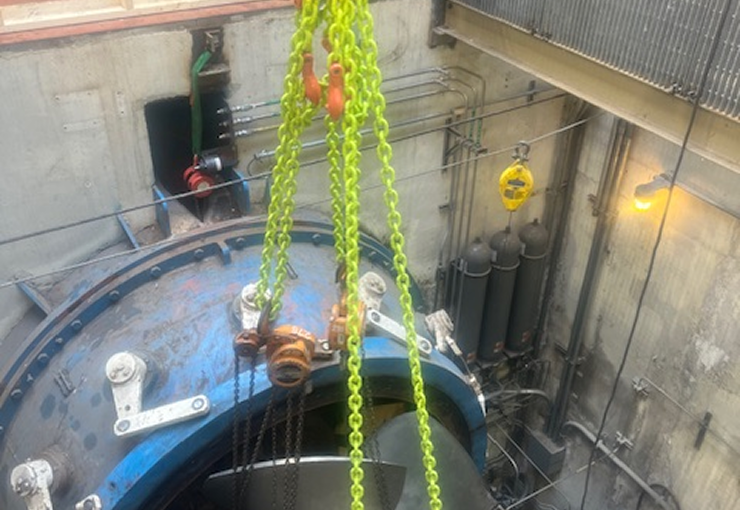 Bright yellow chains suspending a blue turbine, likely in an industrial setting.
