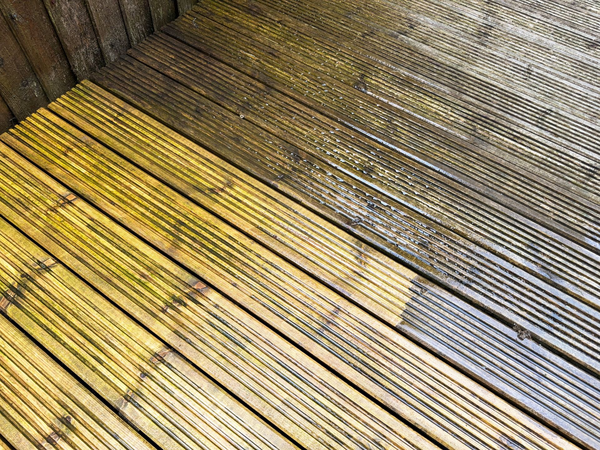 Mossy wooden deck boards with faded yellow and gray sections, viewed from above