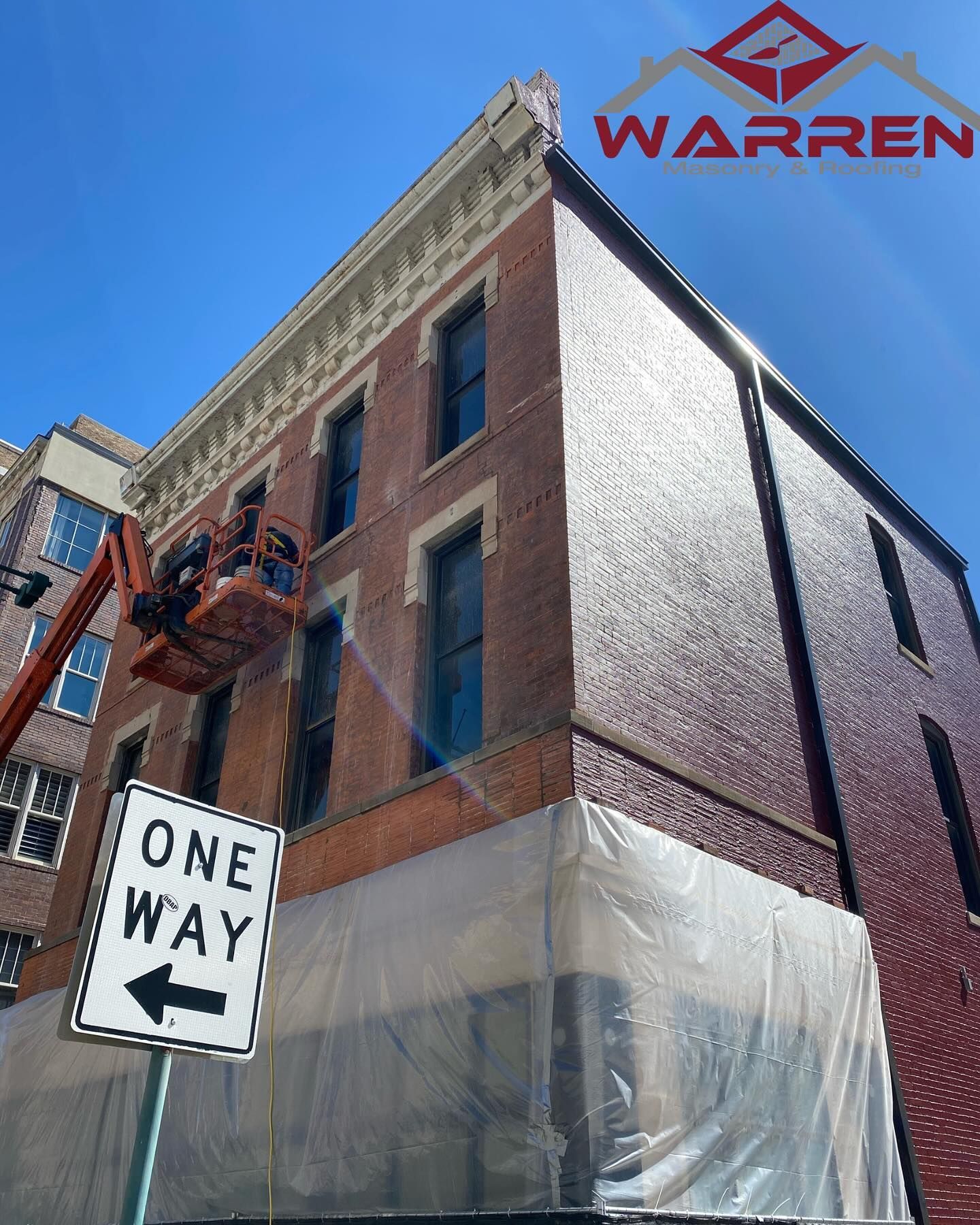 A Dunkin' building under construction, featuring scaffolding along the front and side with an orange awning and logo.