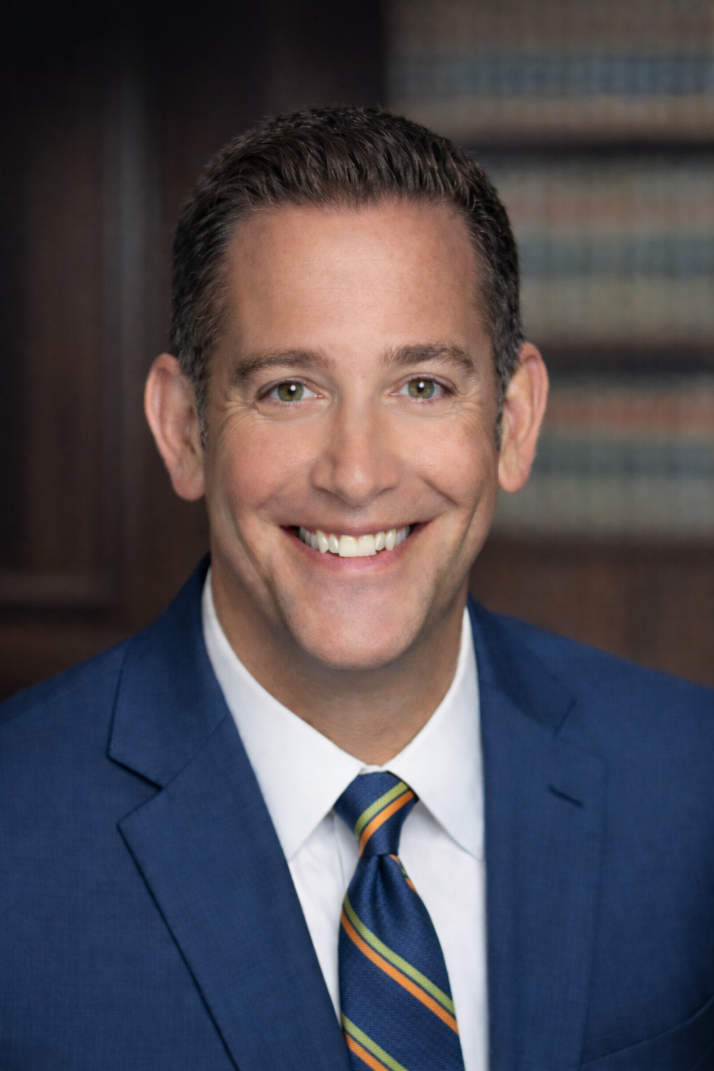 Smiling man in blue suit, looking at the camera.