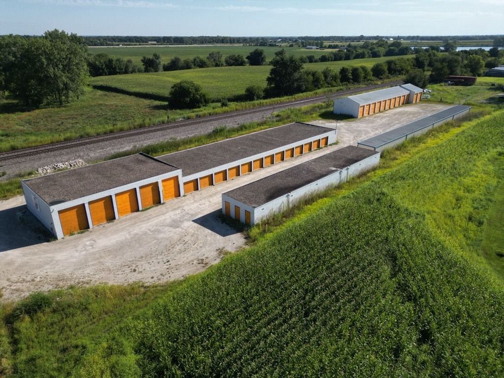 An aerial view of a row of garages in a field.