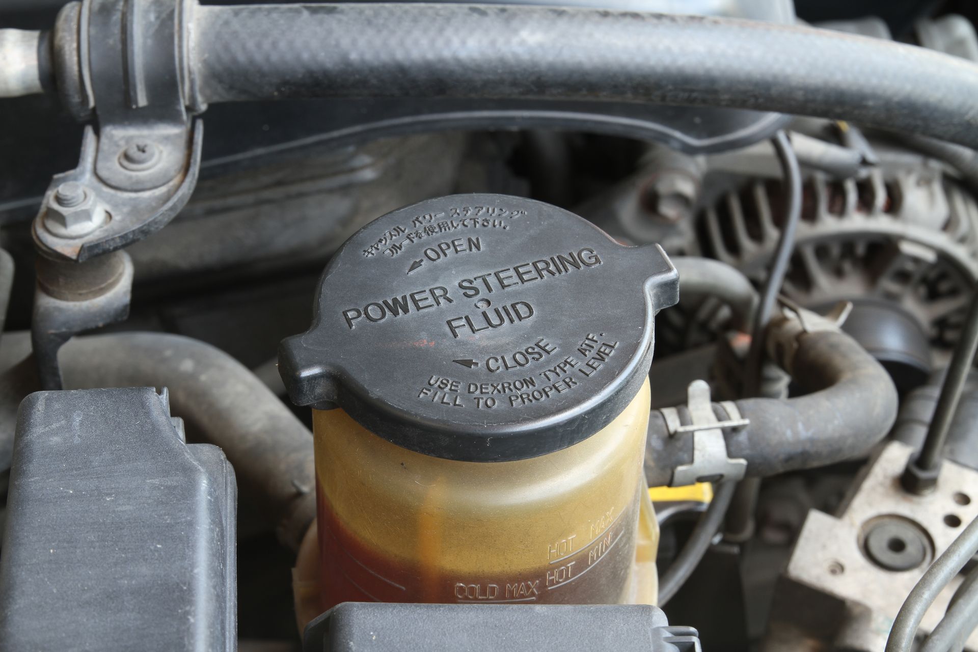 a close-up of a power steering fluid container in a car engine