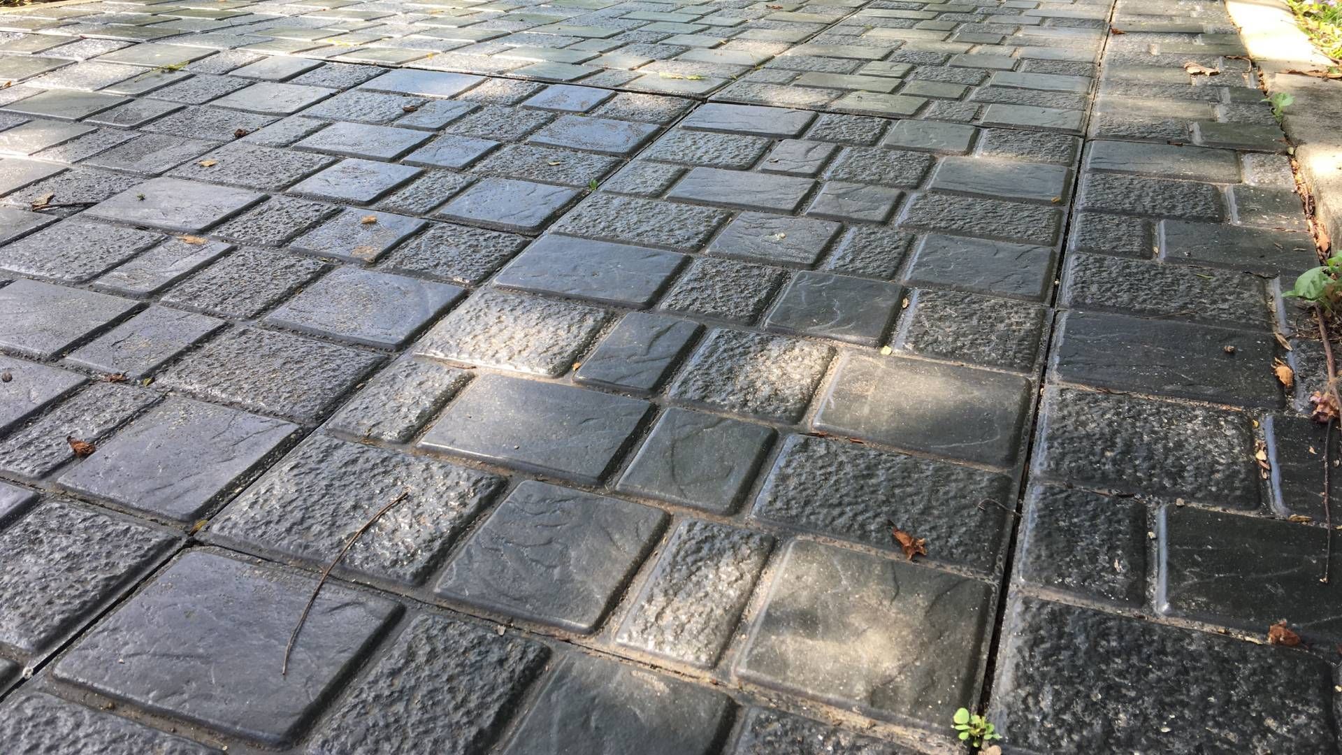 A close up of a brick walkway with a diagonal pattern.