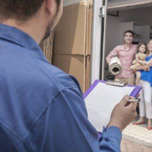A man is holding a clipboard in front of a family.