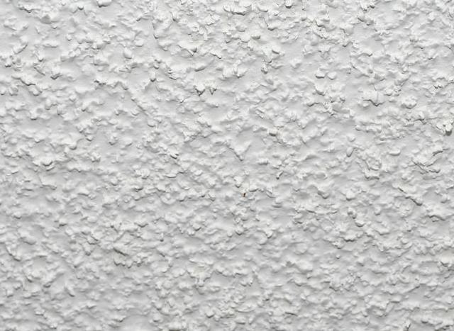 A close up of a white wall with a rough texture.