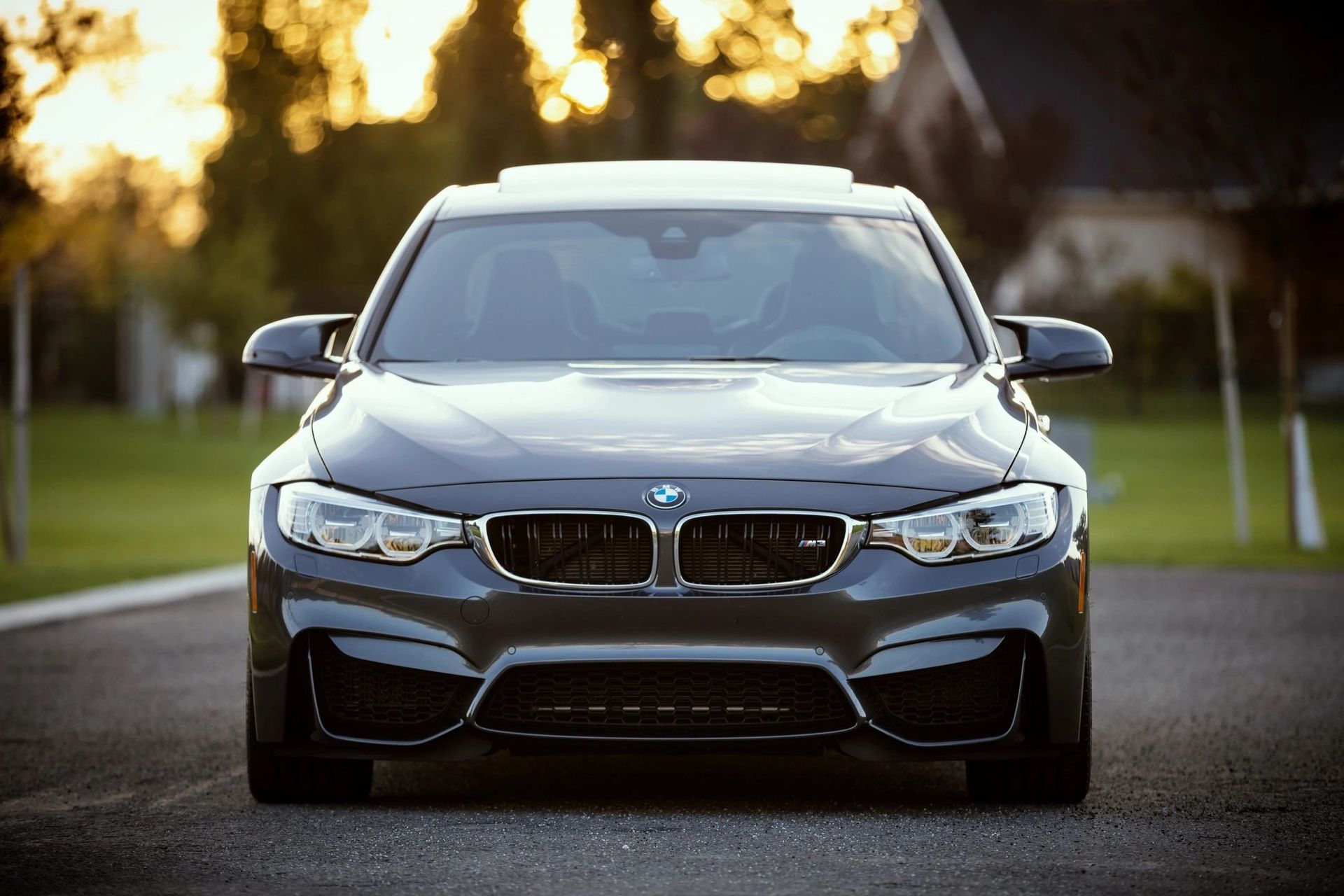 Dark gray BMW M3 parked on asphalt.