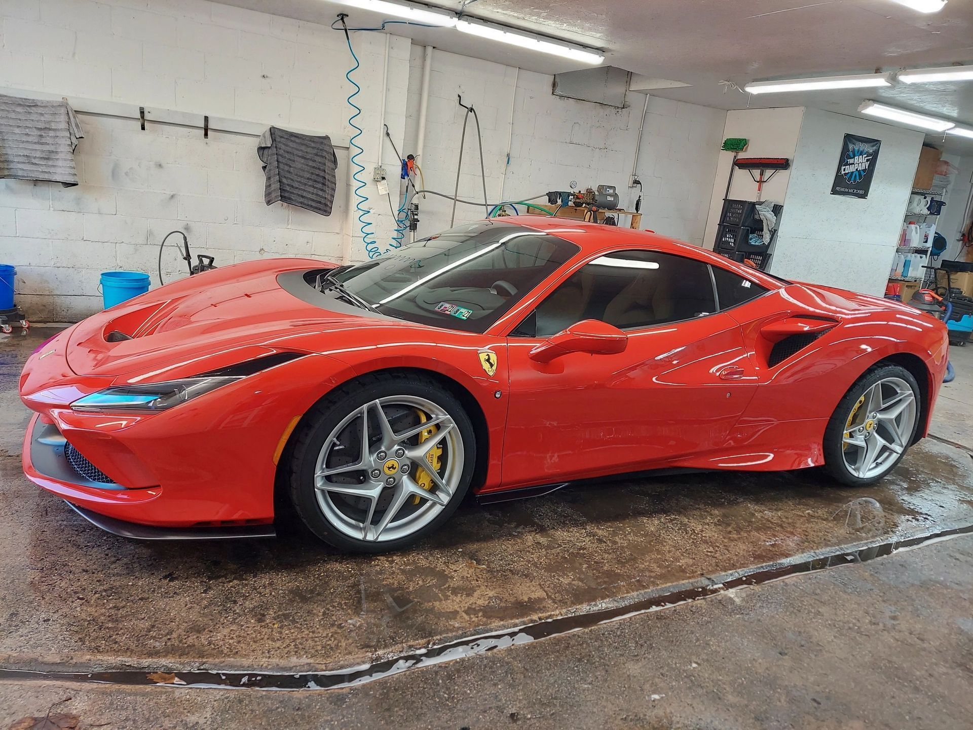 Bright red Ferrari sports car parked indoors; detailed view of the sleek exterior and wheels.