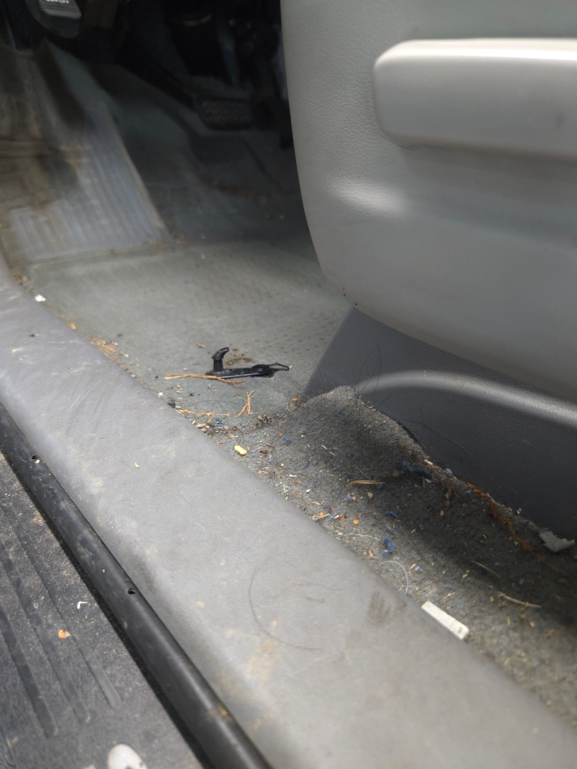 Person steaming a car dashboard, wiping with a green cloth. White steam billows.