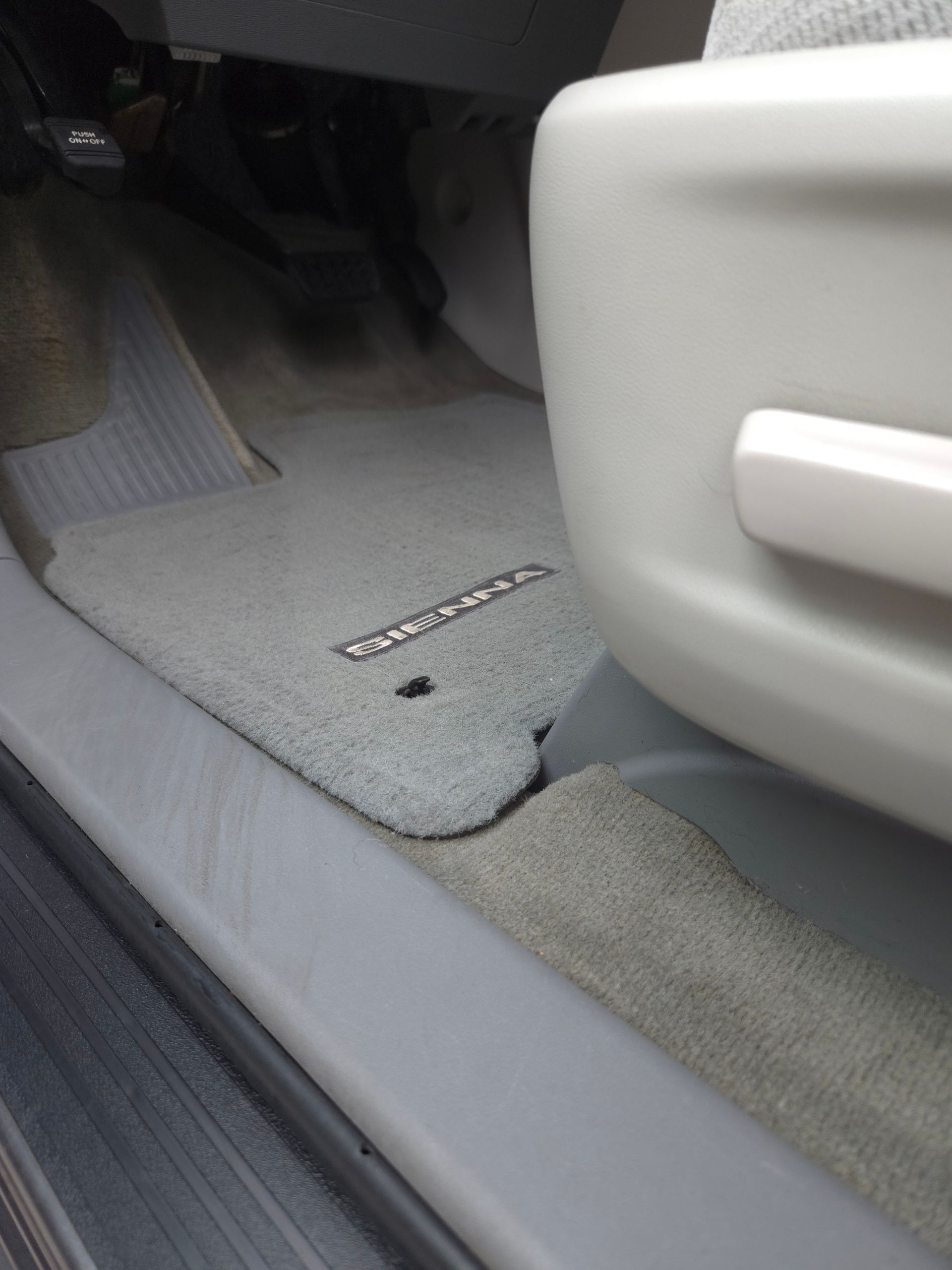 Person cleaning tan leather car seat with a white cloth and wearing a black glove.