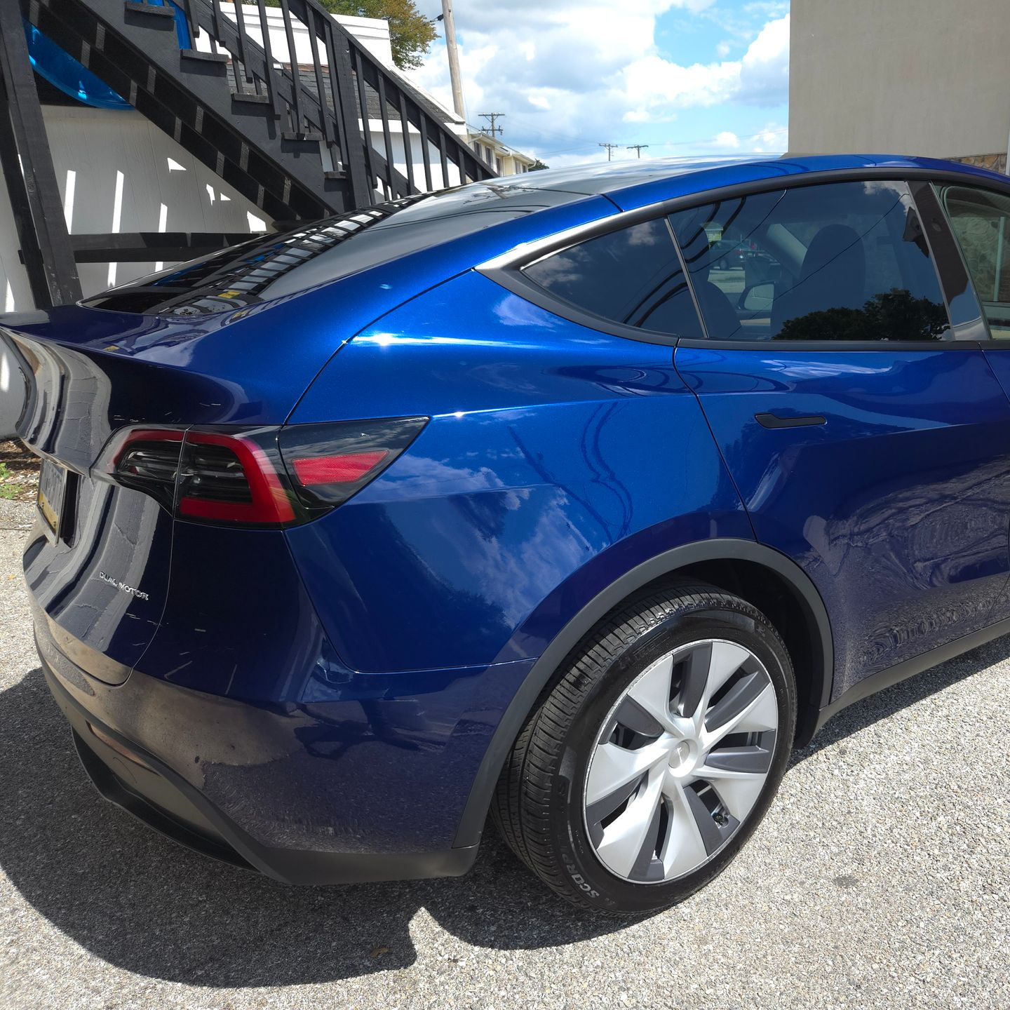 Blue Tesla Model Y, parked outside with a modern, angular design.